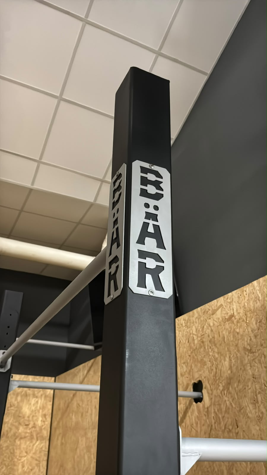 Placa troquelada BÄR en la columna del rack de barras